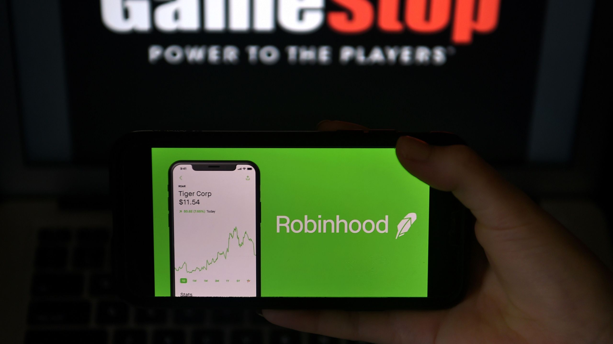 This photo illustration shows the logos of video grame retail store GameStop and trading application Robinhood in a computer and on a mobile phone in Arlington, Virginia on Jan. 28, 2021. An epic battle is unfolding on Wall Street, with a cast of characters clashing over the fate of GameStop, a struggling chain of video game retail stores. The conflict has sent GameStop on a stomach-churning ride with amateur investors taking on the financial establishment in the mindset of the Occupy Wall Street movement launched a decade ago. (Olivier DOULIERY / AFP via Getty Images)