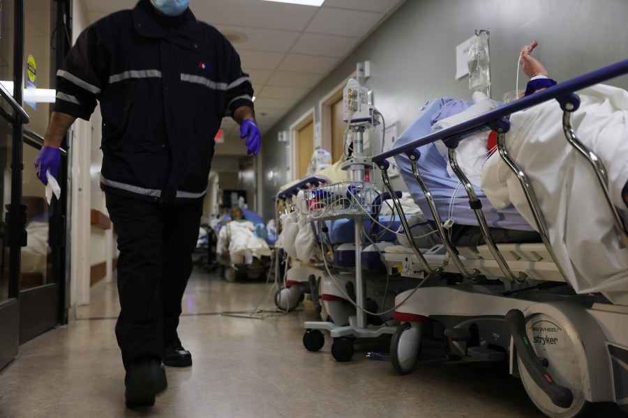 A patient lies on a stretcher in a hallway near other patients in the overloaded emergency room at Providence St. Mary Medical Center in Apple Valley on Jan. 5, 2021. (Mario Tama / Getty Images)