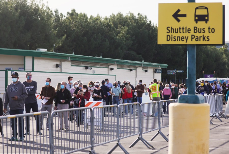 People wait in line to receive the COVID-19 vaccine at a mass vaccination site in a parking lot for Disneyland Resort on January 13, 2021 in Anaheim, California. (Photo by Mario Tama/Getty Images)