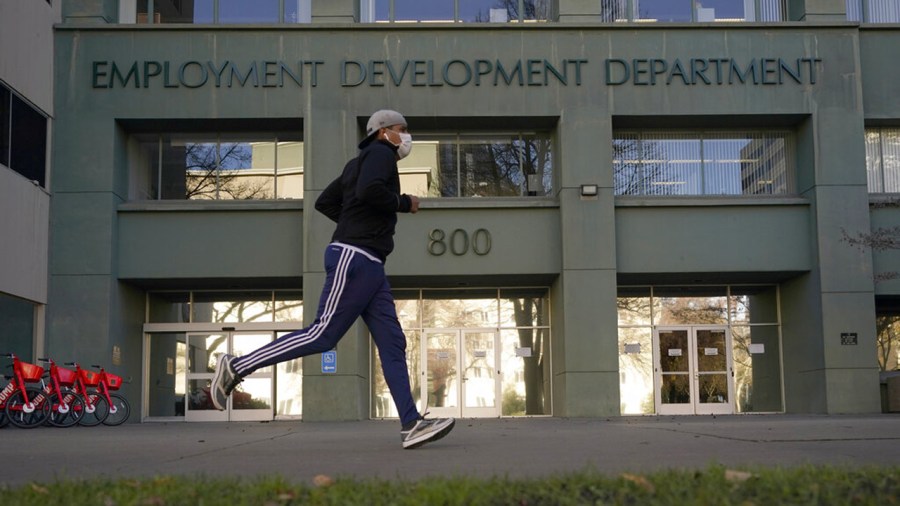 A runner passes the office of the California Employment Development Department in Sacramento on Dec. 18, 2020. (Rich Pedroncelli / Associated Press)