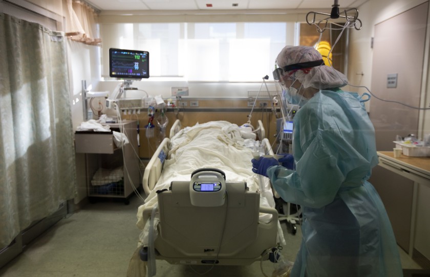 A nurse brings medication to a COVID-19 patient in an hospital intensive care unit.(Francine Orr/Los Angeles Times)