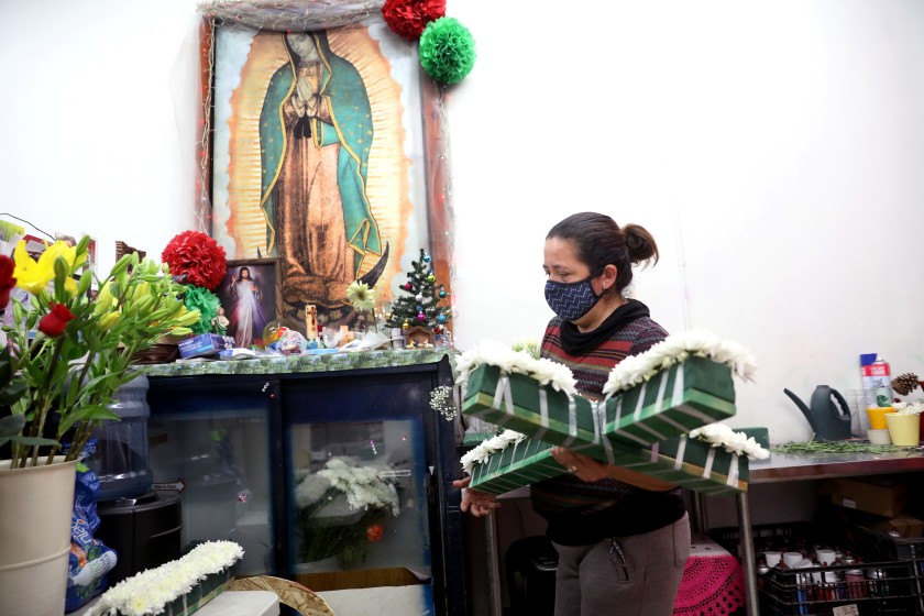 Elizabeth Garibay prepares a floral cross for a funeral at her family business J & I Florist on Dec. 17 in Los Angeles. (Gary Coronado / Los Angeles Times)