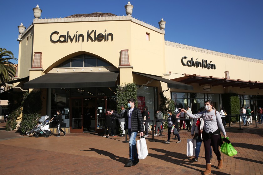 Shoppers wait in line to enter the Calvin Klein store at the Citadel Outlets in Commerce on Dec. 22, 2020. (Dania Maxwell / Los Angeles Times)