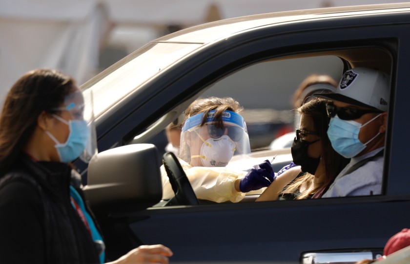 Drivers pull up for inoculations on Jan. 19 in the parking lot of the Forum in Inglewood. (Al Seib / Los Angeles Times)