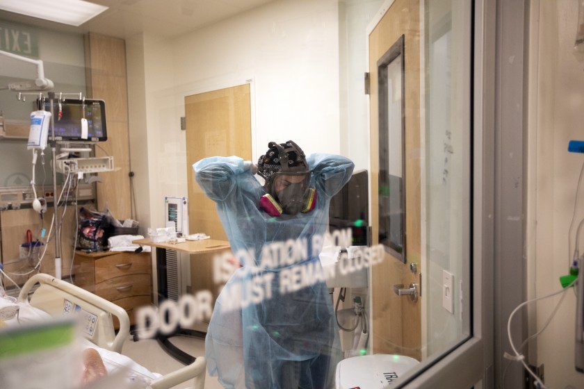 Registered nurse Armela Masihi walks out of a COVID-positive patients room in ICU at Martin Luther King Community Hospital. (Francine Orr/Los Angeles Times)