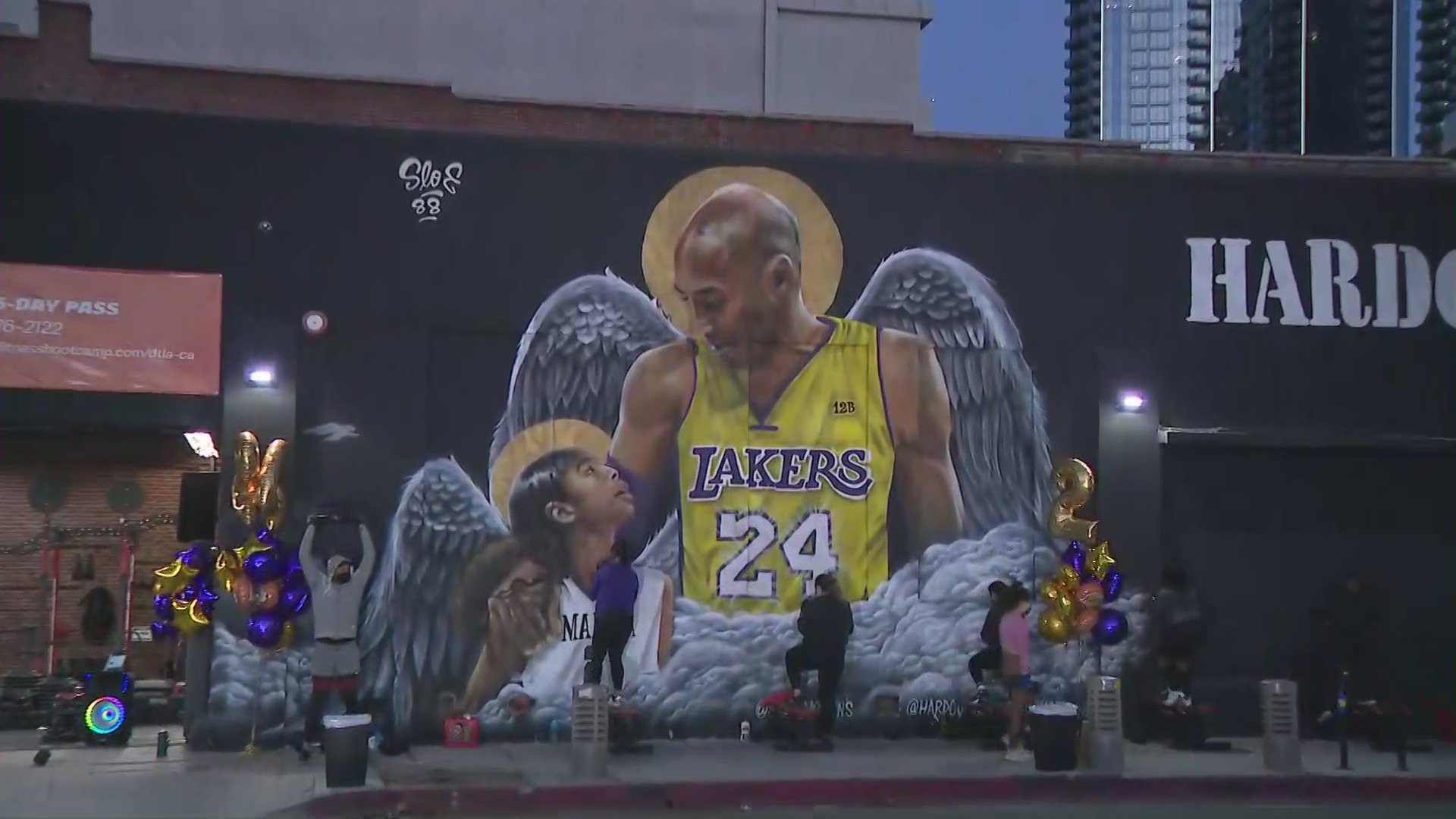 People gather at a Kobe and Gianna Bryant mural at Pico Boulevard and Grand Avenue in downtown Los Angeles on Jan. 26, 2021, a year after their death. (KTLA)