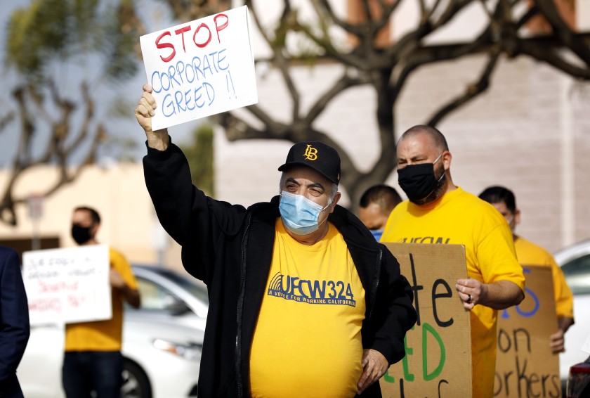 Long Beach resident Howard Simmons, a cashier at a Ralph’s in Huntington Beach, shows his support for Food 4 Less workers at the store on South Street in North Long Beach on Feb 3, 2021. (Christina House / Los Angeles Times)