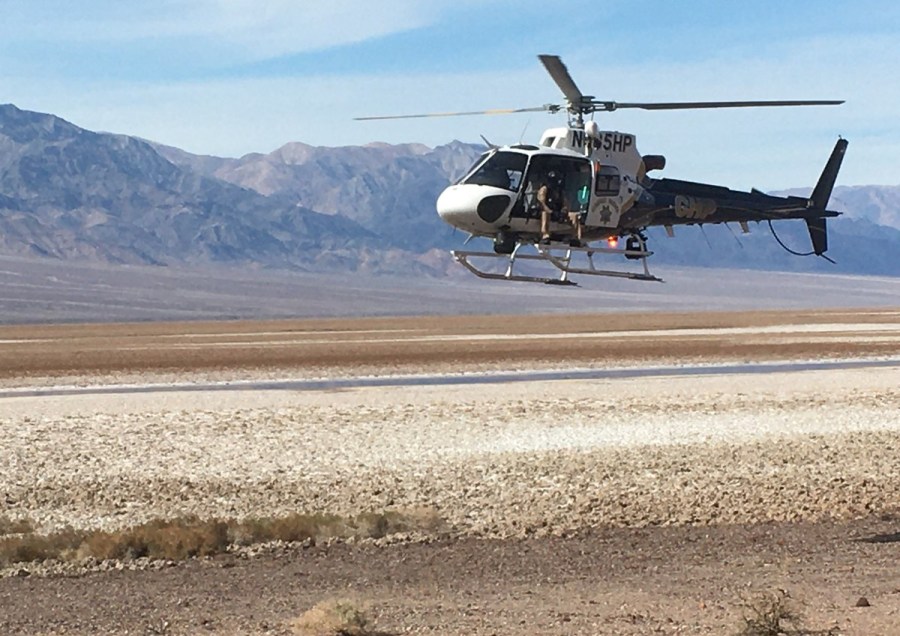 California Highway Patrol's H-82 helicopter is seen returning to the staging area adjacent to Badwater Road after dropping off Inyo County SAR team members in Deimos Canyon on Jan. 30, 2021. (NPS)