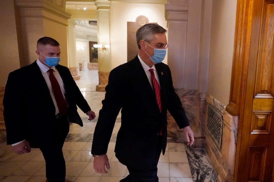 Georgia Secretary of State Brad Raffensperger, right, walks to his office in the Capitol Building Monday, Jan. 4, 2021, in Atlanta. (AP Photo/John Bazemore)