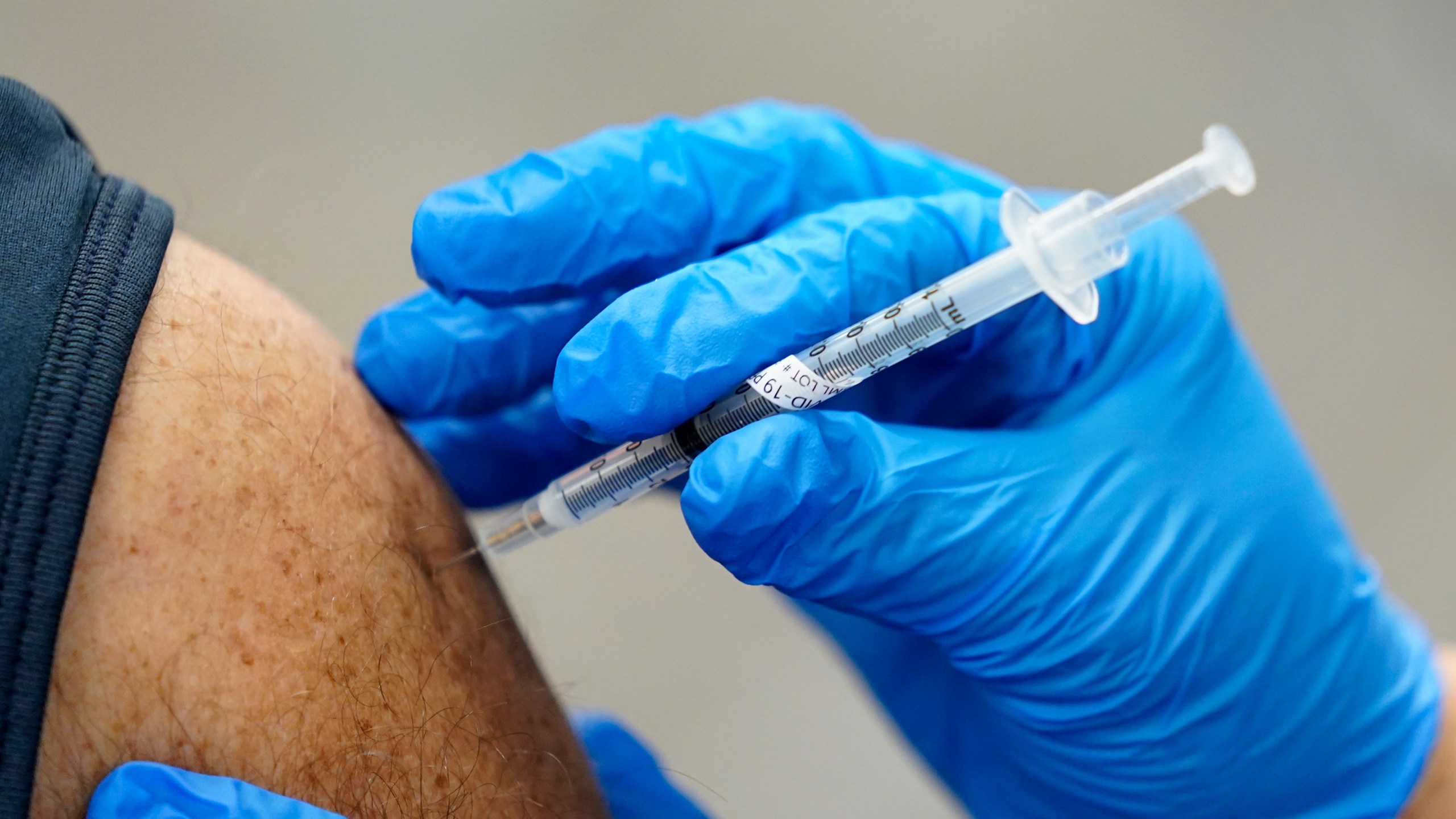 In this Jan. 5, 2021, file photo, healthcare worker receives a second Pfizer-BioNTech COVID-19 vaccine shot at Beaumont Health in Southfield, Mich. (AP Photo/Paul Sancya, File)