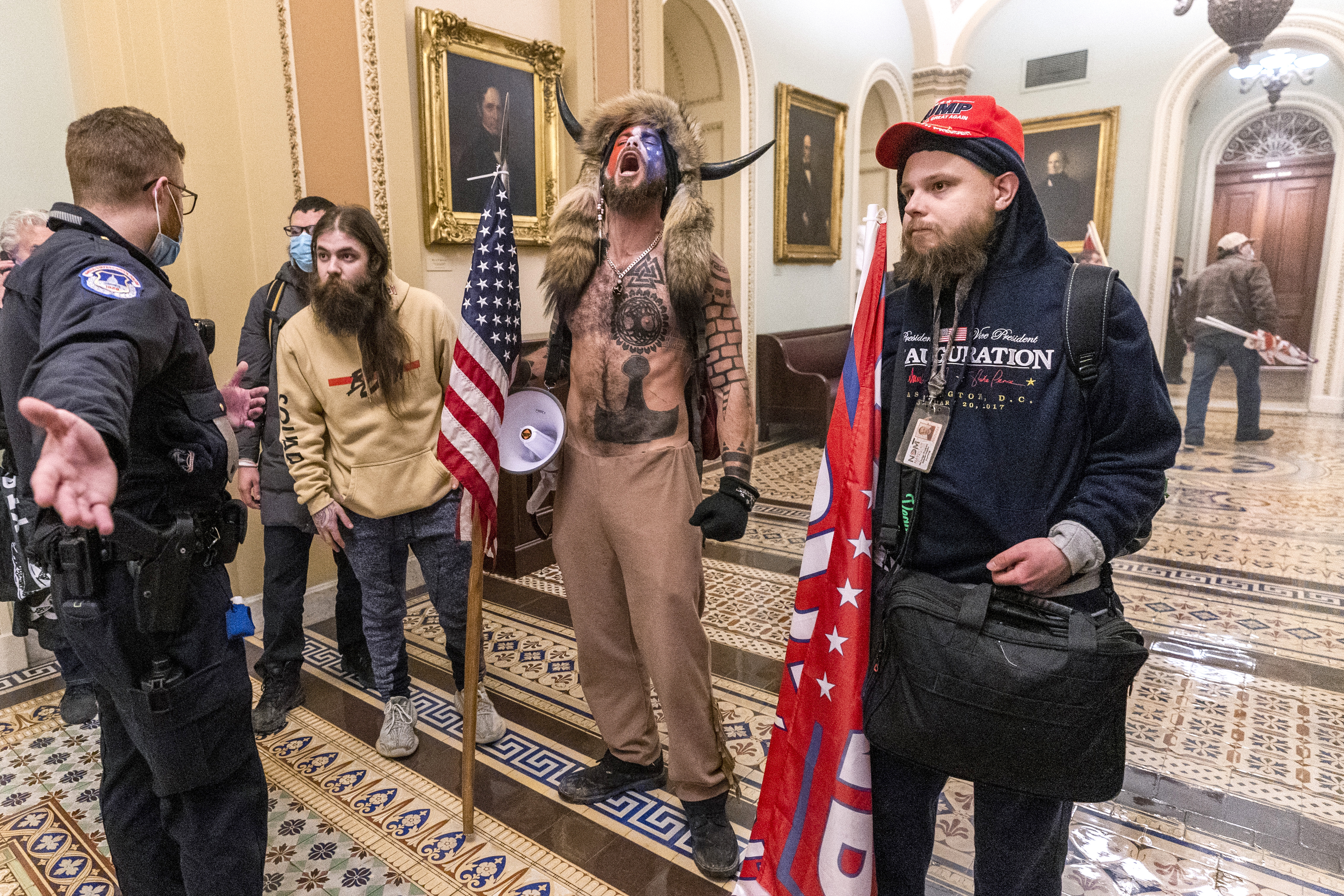 In this Wednesday, Jan. 6, 2021 file photo, supporters of President Donald Trump, including Jacob Chansley, center with fur hat, are confronted by Capitol Police officers outside the Senate Chamber inside the Capitol in Washington. (AP Photo/Manuel Balce Ceneta)