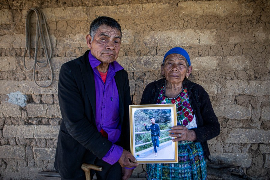 German and Maria Tomas pose for a photograph holding a framed portrait of their grandson Ivan Gudiel, at their home in Comitancillo, Guatemala, Wednesday, Jan. 27, 2021. They believe their grandson is one of the 13 of the 19 charred corpses found in a northern Mexico border state on Saturday. The country's Foreign Ministry said it was collecting DNA samples from a dozen relatives to see if there was a match with any of the bodies. (AP Photo/Oliver de Ros)