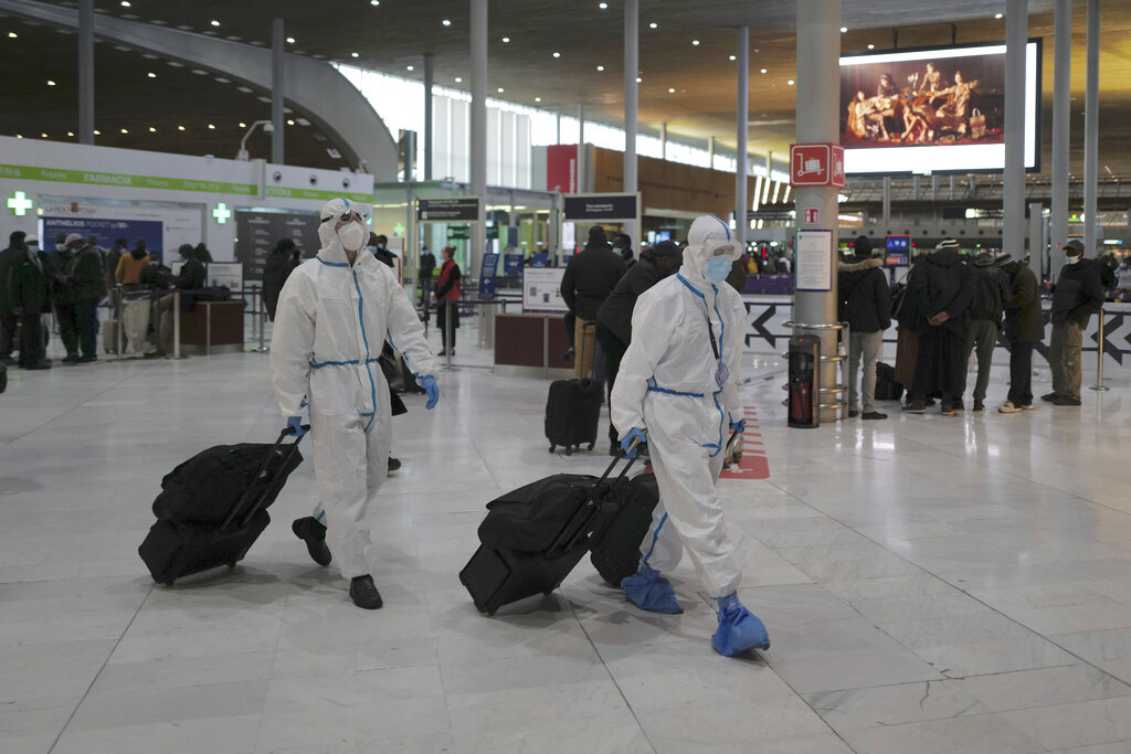 Passengers from Taiwan wearing protective gear arrive to board their plane at Paris Charles de Gaulle Airport in Roissy , north of Paris, Monday, Feb. 1, 2021. (AP Photo/Francois Mori)