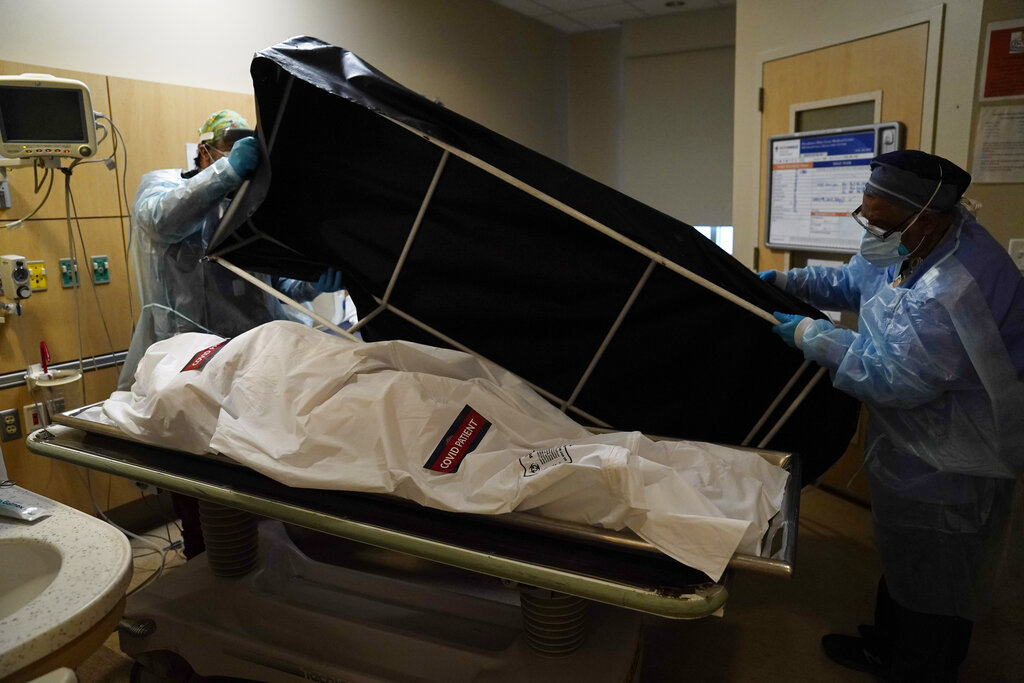 In this Jan. 9, 2021, file photo, transporters prepare to move a body of a COVID-19 victim to a morgue at Providence Holy Cross Medical Center in Mission Hills. (AP Photo/Jae C. Hong, File)