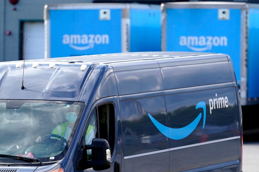 FILE - In this Oct. 1, 2020 file photo, an Amazon Prime logo appears on the side of a delivery van as it departs an Amazon Warehouse location in Dedham, Mass. Amazon is paying nearly $62 million to settle charges that it took tips from its delivery drivers. The Federal Trade Commission said Tuesday, Feb. 2, 2021, that for more than two years, Amazon didn’t pass on tips to drivers, even though it promised shoppers and drivers it would do so. (AP Photo/Steven Senne, File)