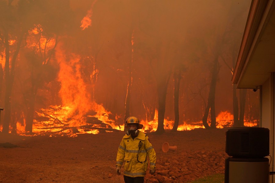 In this photo provided by Department of Fire and Emergency Services, a firefighter attends a fire near Wooroloo, northeast of Perth, Australia, on Feb. 2, 2021. (Evan Collis/DFES via Associated Press)