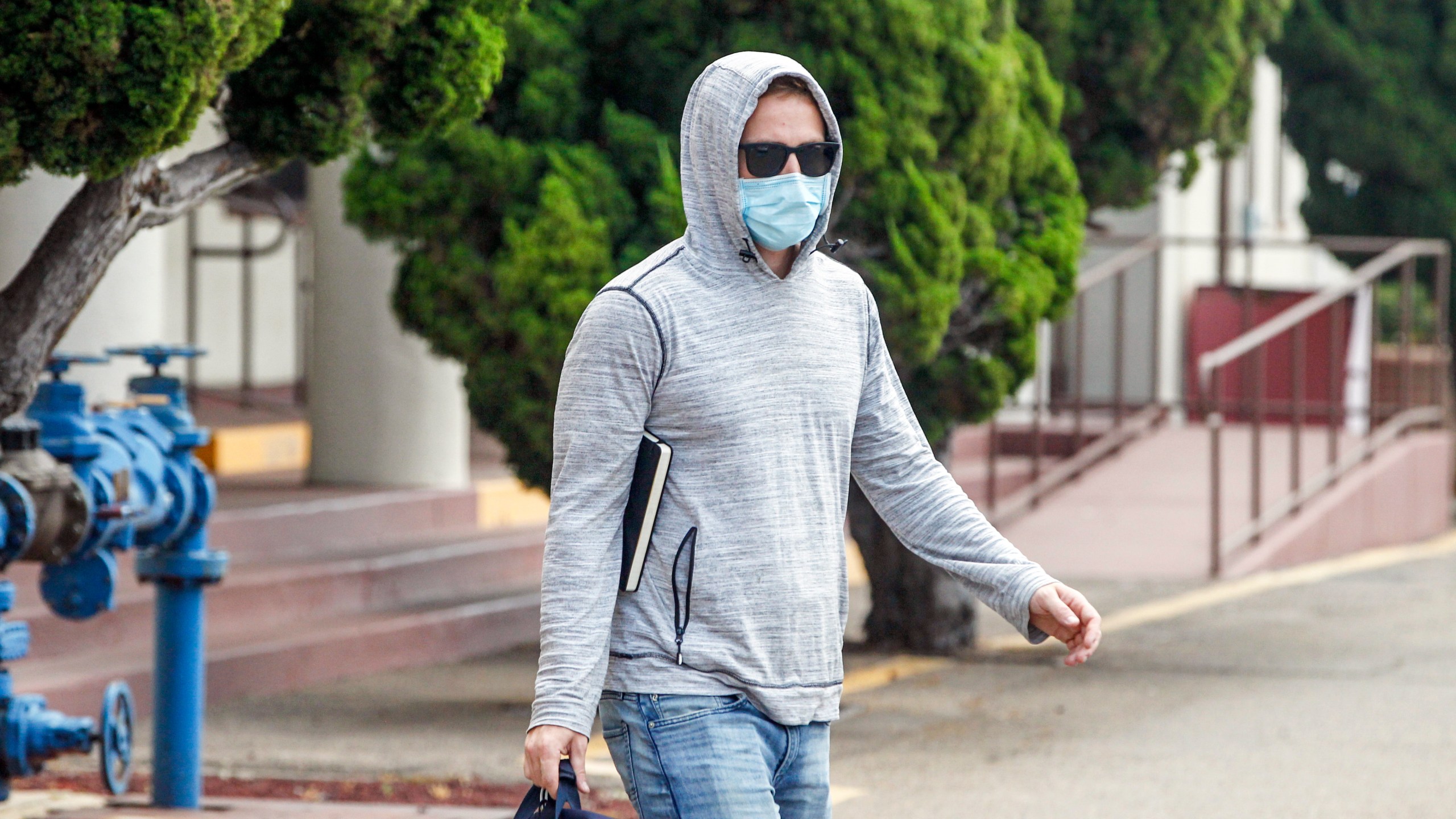 Petty Officer First Class Adel Enayat leaves the building after appearing for a hearing at Naval Base San Diego on Aug. 21, 2020, in San Diego. (Eduardo Contreras/The San Diego Union-Tribune via AP)