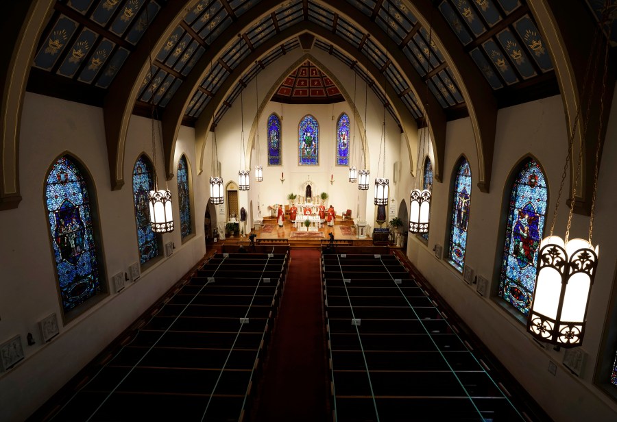 In this April 5, 2020, file photo, The Most Rev. Peter Jugis, Bishop of Charlotte, conducts Palm Sunday services inside the empty St. Patrick Cathedral in Charlotte, N.C. (David T. Foster III/The Charlotte Observer via AP)