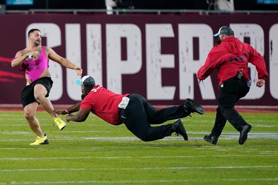 Security tries to grab a fan on the field during the second half of the NFL Super Bowl 55 football game between the Tampa Bay Buccaneers and the Kansas City Chiefs, Sunday, Feb. 7, 2021, in Tampa, Fla. (AP Photo/Mark Humphrey)