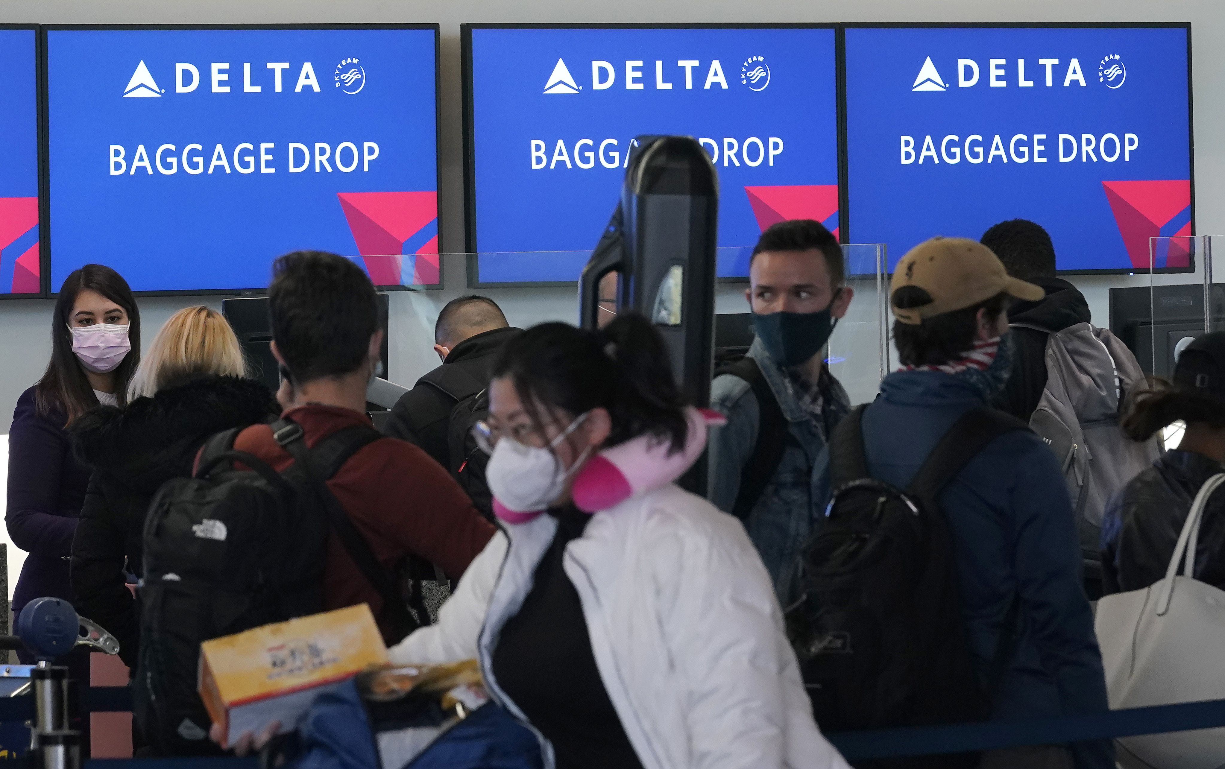 People wait in line at a Delta Air Lines gate at San Francisco International Airport during the coronavirus pandemic in San Francisco, Tuesday, Dec. 22, 2020. (AP Photo/Jeff Chiu)