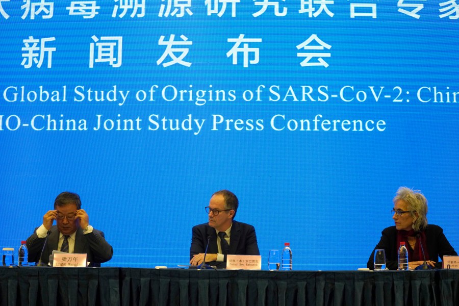 Marion Koopmans, right, and Peter Ben Embarek, center, of a World Health Organization team look over at their Chinese counterpart Liang Wannian, left, during a WHO-China Joint Study Press Conference held at the end of their mission to investigate the origins of the coronavirus pandemic in Wuhan in central China's Hubei province, Tuesday, Feb. 9, 2021. (AP Photo/Ng Han Guan)