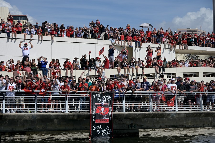 Fans watch the Tampa Bay Buccaneers celebrate their Super Bowl 55 victory over the Kansas City Chiefs with a boat parade in Tampa, on Feb. 10, 2021. (Phelan Ebenhack/Associated Press)