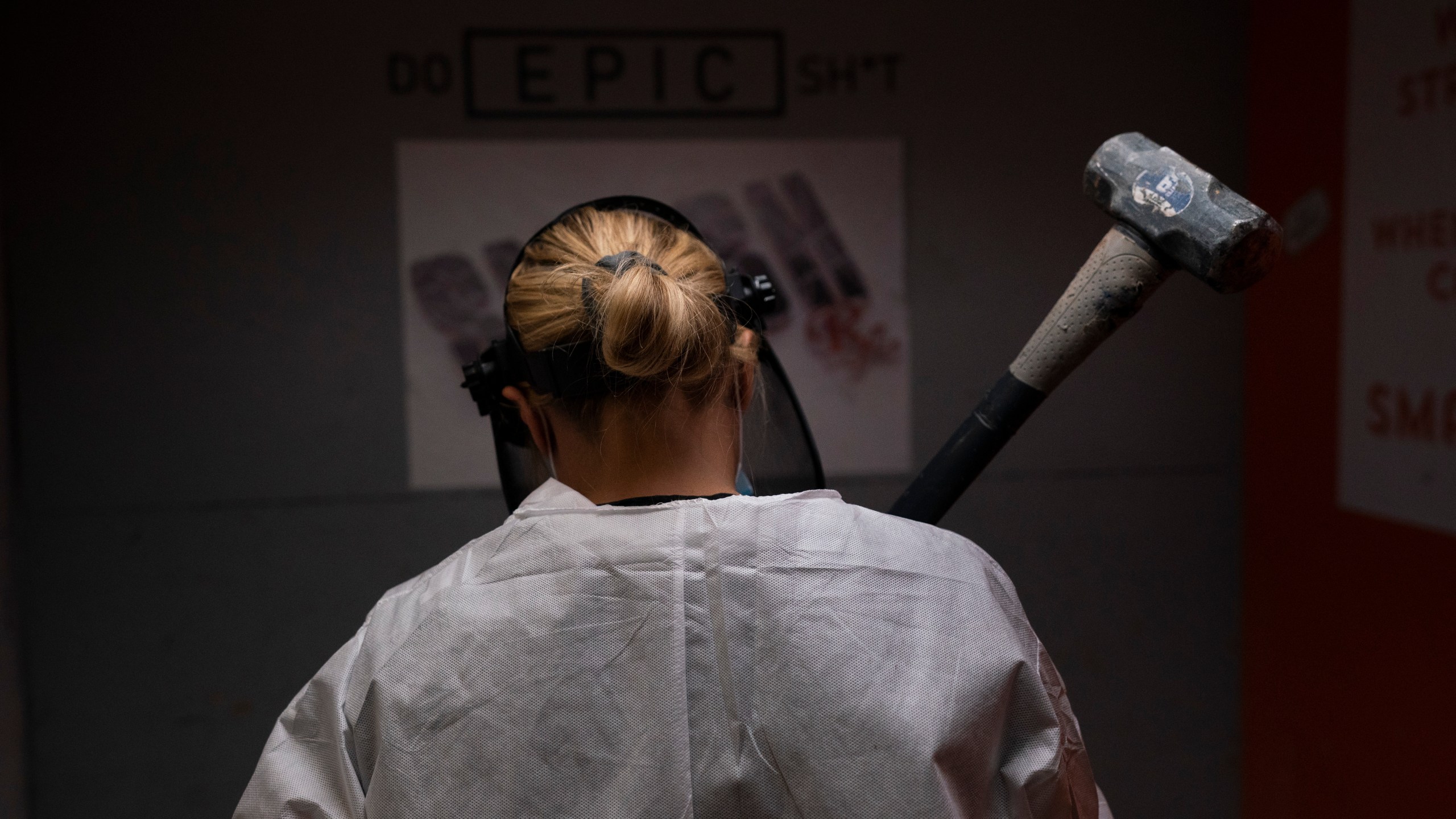 Michelle Elohim, a mother of four children, holds a hammer to smash a side table in a rage room at Smash RX in Westlake Village on Feb. 5, 2021. (Jae C. Hong / Associated Press)