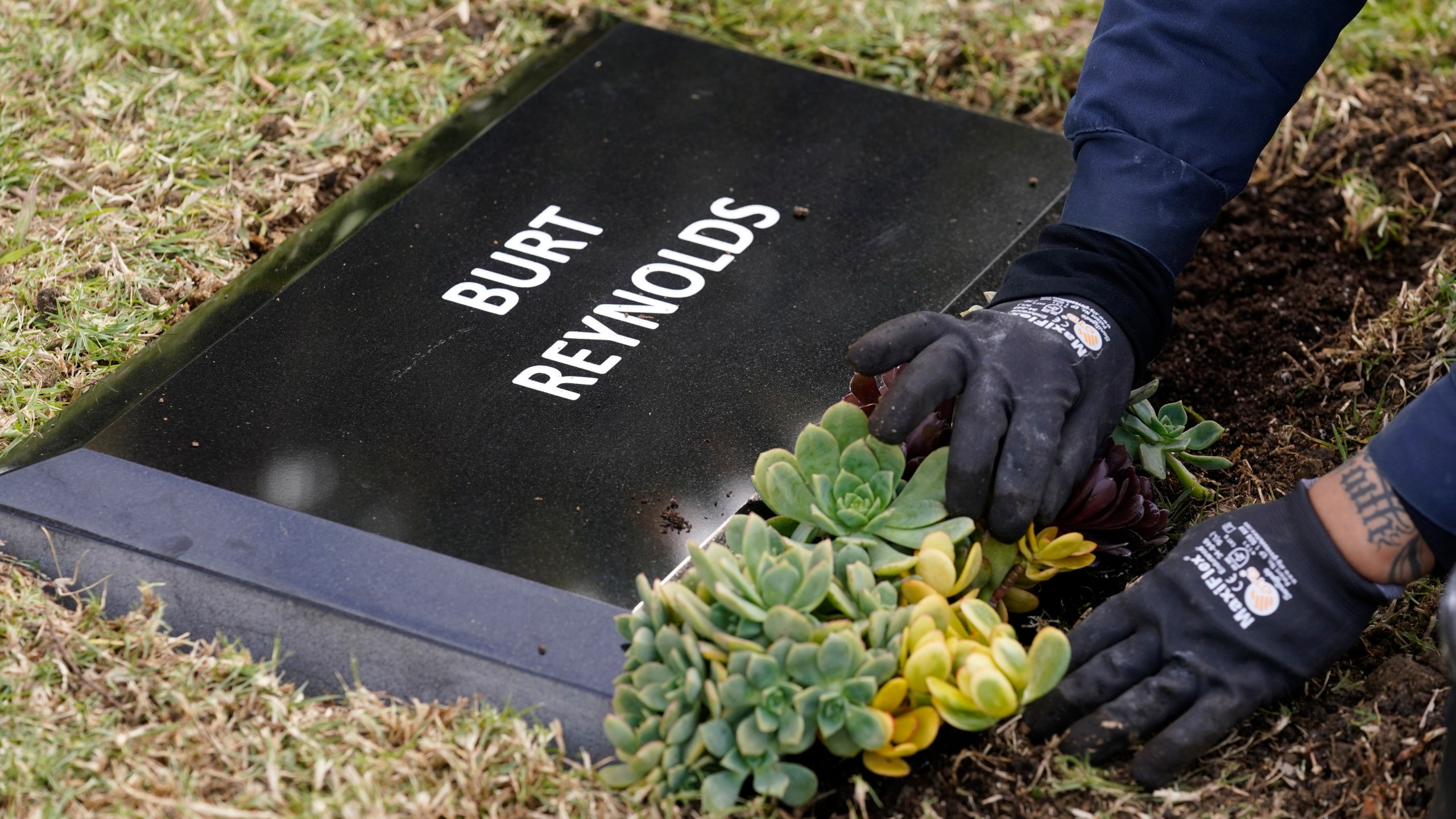 Flowers are placed in front of a temporary headstone for the late actor Burt Reynolds in the Garden of Legends section of Hollywood Forever cemetery, on Feb. 11, 2021. (Chris Pizzello/Associated Press)