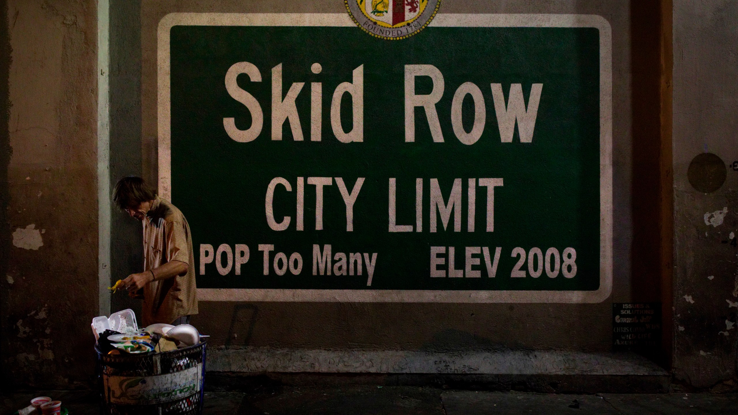 A homeless man takes food from a trash can in Los Angeles' Skid Row area, home to the nation's largest concentration of homeless people in Los Angeles, on Oct. 28, 2017. (Jae C. Hong / Associated Press)