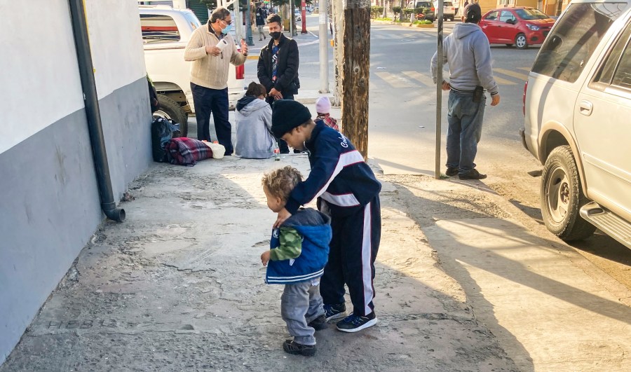 Honduran boys whose family wants to seek asylum in the U.S., play on the sidewalk in Tijuana, Mexico, Monday, Feb. 8, 2021. (AP Photo/Elliot Spagat)