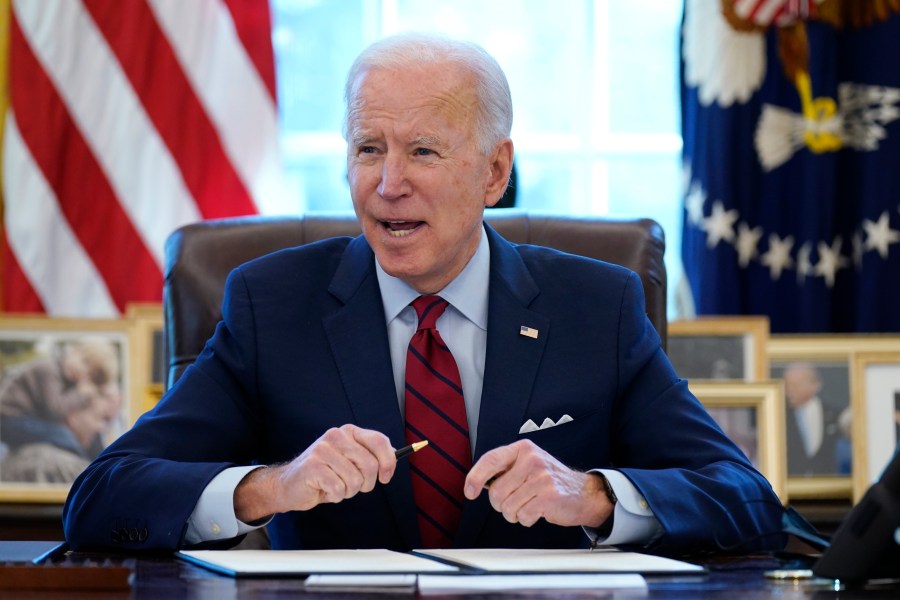 In this Jan. 28, 2021 file photo, President Joe Biden signs a series of executive orders in the Oval Office of the White House in Washington. (AP Photo/Evan Vucci)