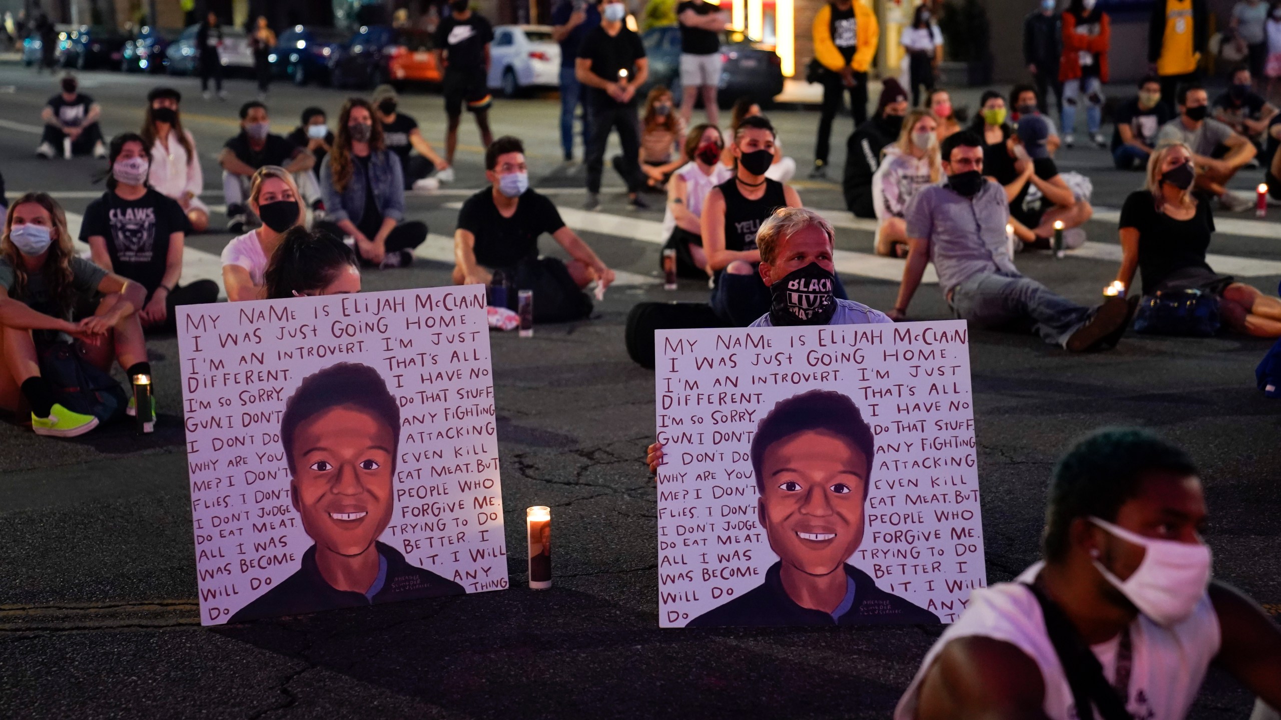 In this Aug. 24, 2020, file photo, two people hold posters showing images depicting Elijah McClain during a candlelight vigil for McClain outside the Laugh Factory in Los Angeles. (Jae C. Hong/Associated Press)