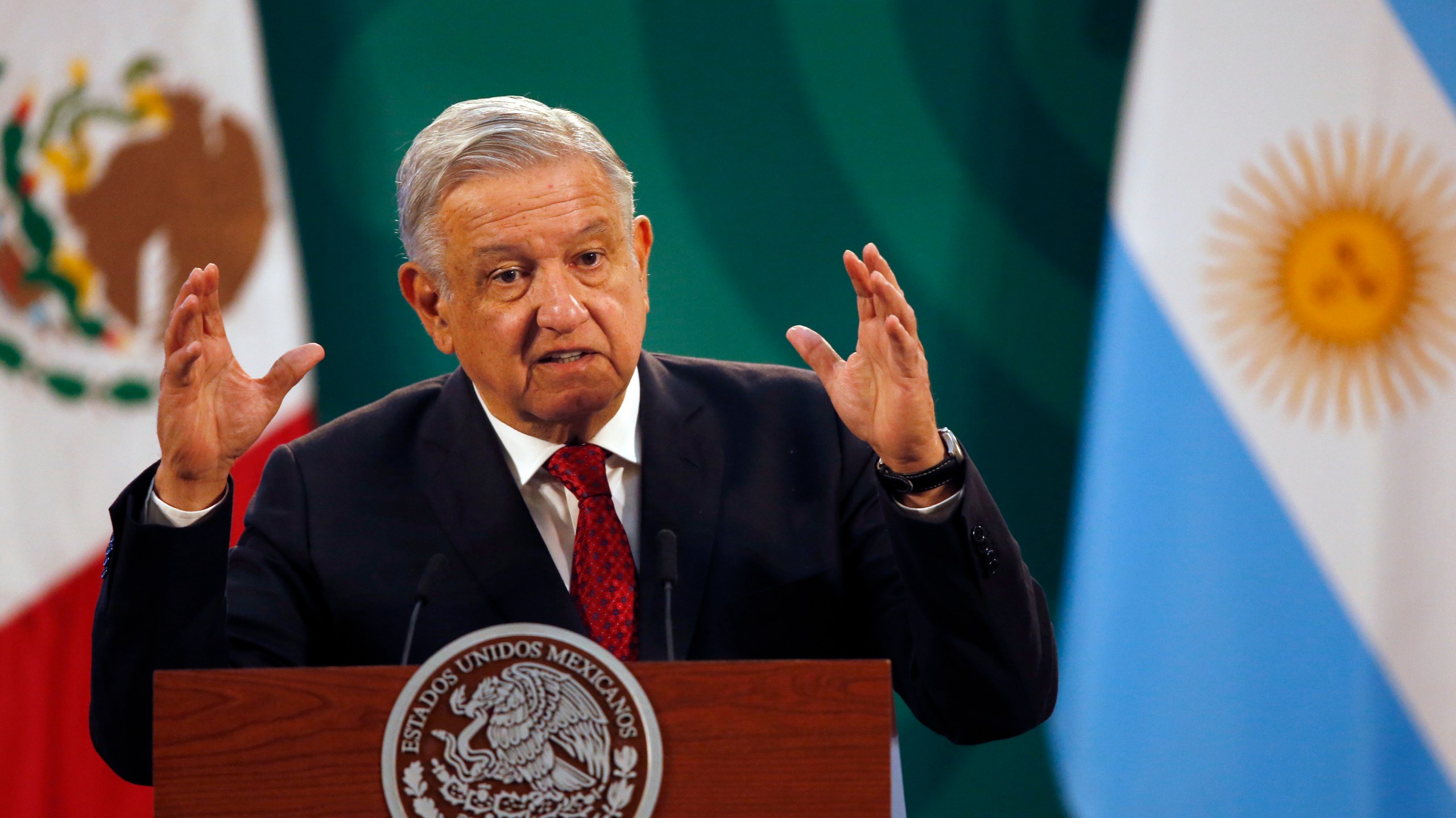 Mexican President Andrés Manuel López Obrador gives his daily, morning press conference at the National Palace in Mexico City, Tuesday, Feb. 23, 2021, with an Argentine flag in the background, right, as Argentine President Alberto Fernandez attends the event. (AP Photo/Marco Ugarte)