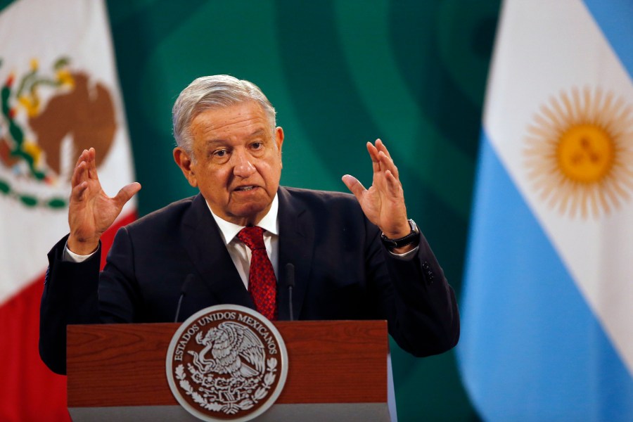 Mexican President Andrés Manuel López Obrador gives his daily, morning press conference at the National Palace in Mexico City, Tuesday, Feb. 23, 2021, with an Argentine flag in the background, right, as Argentine President Alberto Fernandez attends the event. (AP Photo/Marco Ugarte)