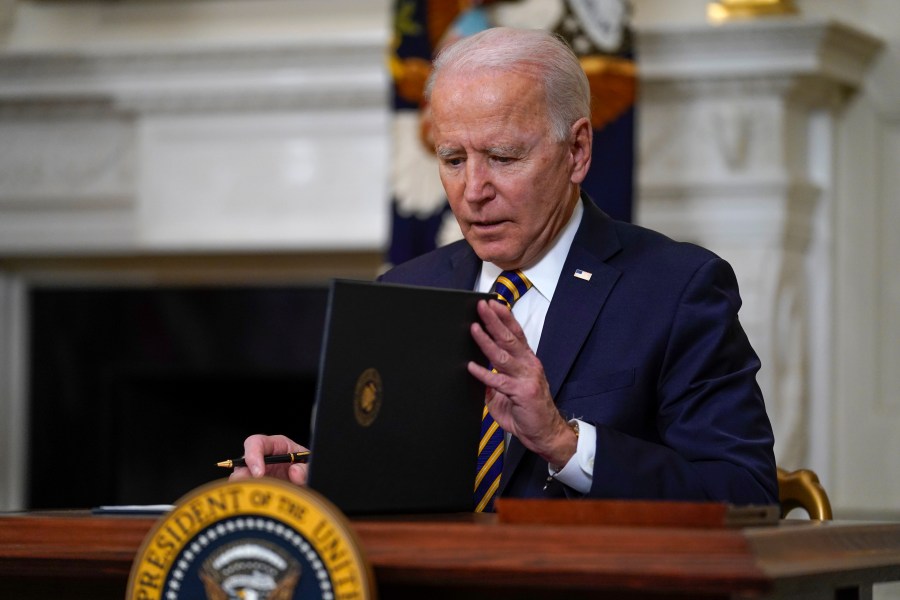 President Joe Biden closes the folder after signing an executive order relating to U.S. supply chains, in the State Dining Room of the White House on Feb. 24, 2021. (Evan Vucci / Associated Press)