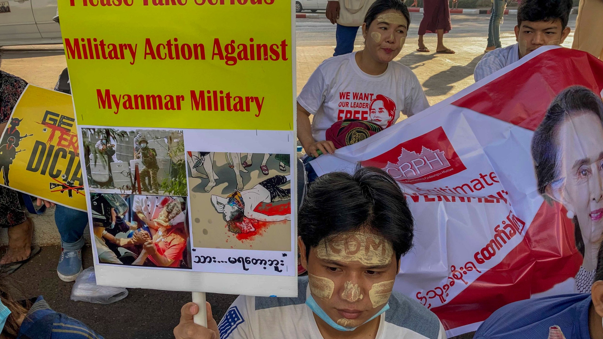 An anti-coup protester holds a placard requesting military action against Myanmar military in Yangon, Myanmar on Feb. 25, 2021. (AP Photo)