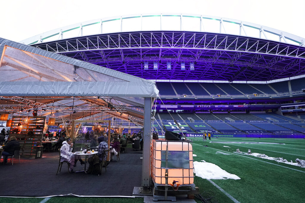 People eat dinner in an outdoor dining tent set up at Lumen Field, the home of the Seattle Seahawks NFL football team, Thursday, Feb. 18, 2021, in Seattle. (AP Photo/Ted S. Warren)