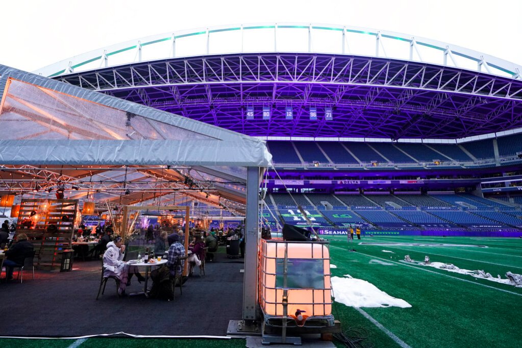 People eat dinner in an outdoor dining tent set up at Lumen Field, the home of the Seattle Seahawks NFL football team, Thursday, Feb. 18, 2021, in Seattle. (AP Photo/Ted S. Warren)