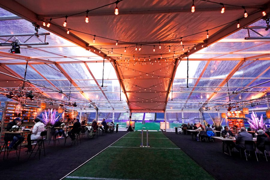 People eat dinner in an outdoor dining tent set up at Lumen Field, the home of the Seattle Seahawks NFL football team, Thursday, Feb. 18, 2021, in Seattle. (AP Photo/Ted S. Warren)