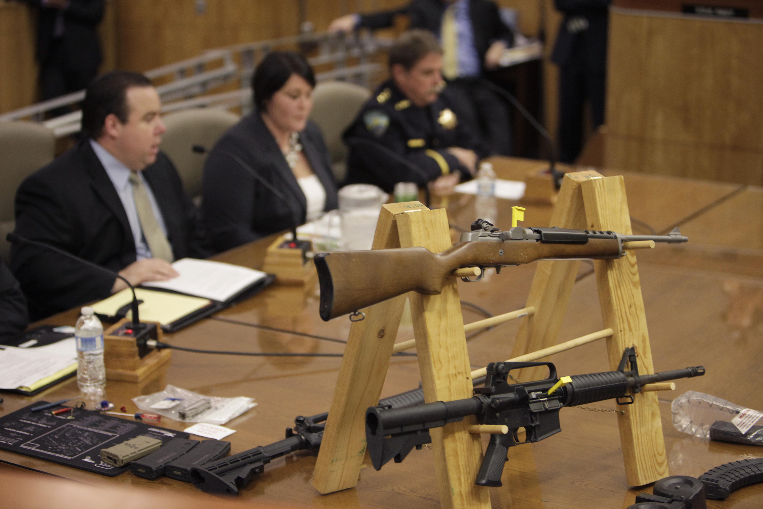 Semi-automatic rifles and large capacity magazines are displayed during a joint legislative informational hearing about gun control at the Capitol in Sacramento on Jan. 29, 2013. (Steve Yeater / Associated Press)