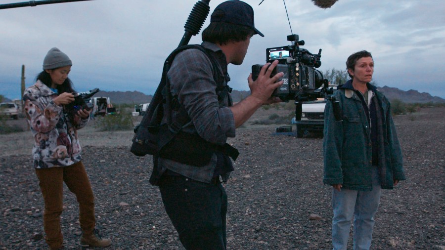 This image released by Searchlight Pictures shows writer-director Chloé Zhao, from left, director of photography Joshua James Richards and actress Frances McDormand on the set of "Nomadland." Zhao has made cinema of rugged authenticity, relying frequently on non-professional actors and moments of serendipity while filming. She is nominated for a Golden Globe for best director. (Searchlight Pictures via AP)