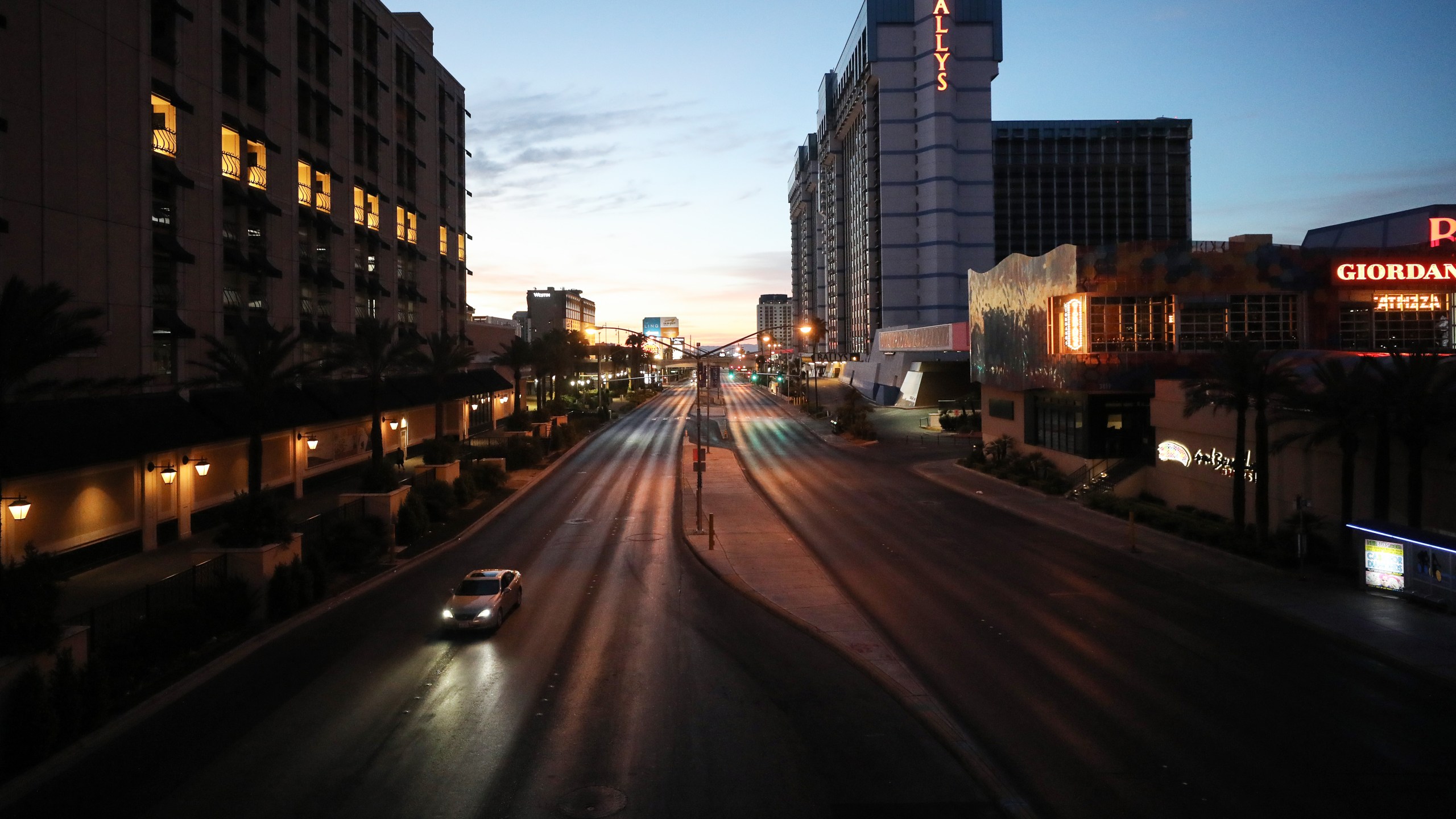 Light traffic passes on a street adjacent to the Las Vegas Strip at dawn, where most businesses have been closed since March 17 in response to the coronavirus (COVID-19) pandemic, on May 27, 2020 in Las Vegas, Nevada.(Mario Tama/Getty Images)