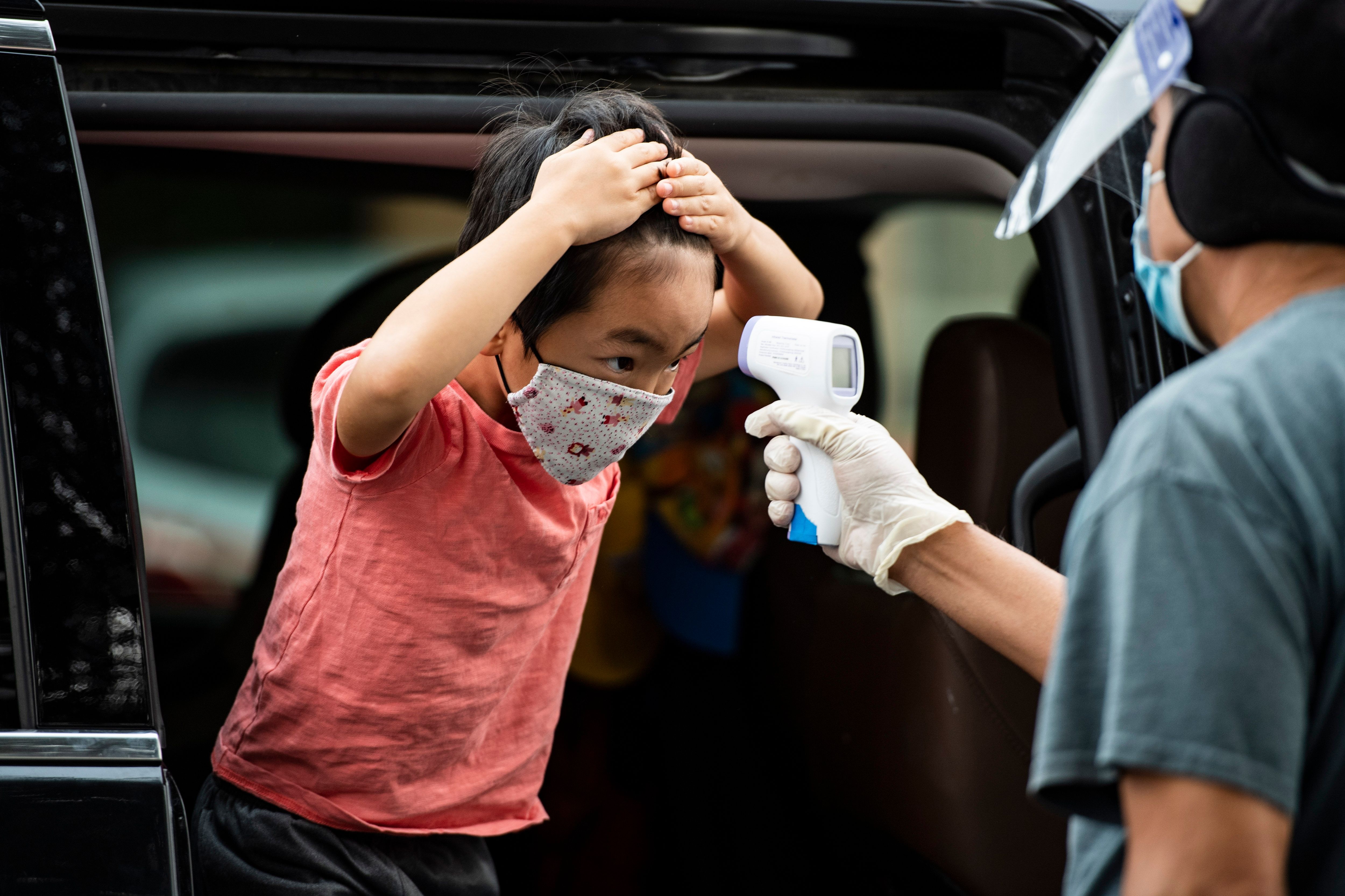 A student has his temperature taken as he arrives at STAR Eco Station Tutoring & Enrichment Center where he will follow his remote school classes, on Sept. 10, 2020, in Culver City, Calif. California public school students will continue to learn at home, in private learning pods, or at specialized enrichment centers like Star Eco Station as the coronavirus pandemic continues, after a lawsuit brought by the Orange County Board of Education seeking to compel the state to reopen public schools was shot down by the California Supreme Court on Sept. 10. (Robyn Beck / AFP via Getty Images)