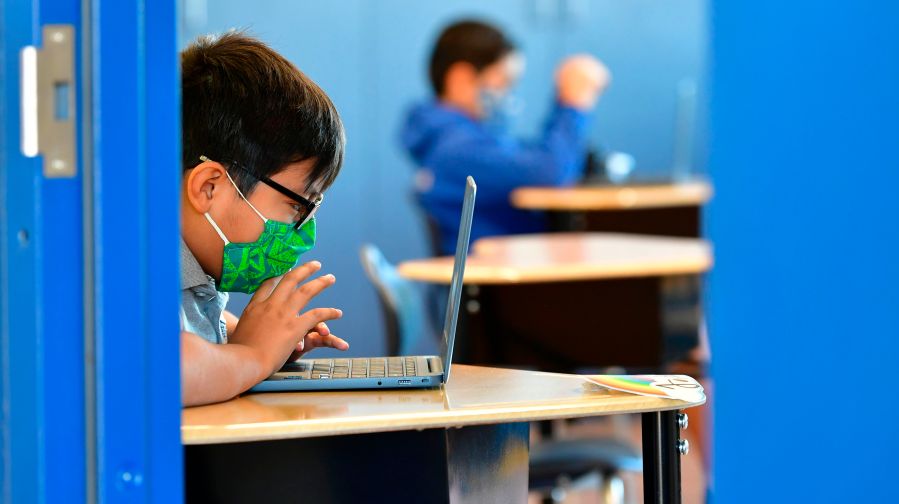 Students work on their laptop computers on Nov. 16, 2020, at St. Joseph Catholic School in La Puente, California, where pre-kindergarten to second grade students in need of special services returned to the classroom for in-person instruction. (FREDERIC J. BROWN/AFP via Getty Images)