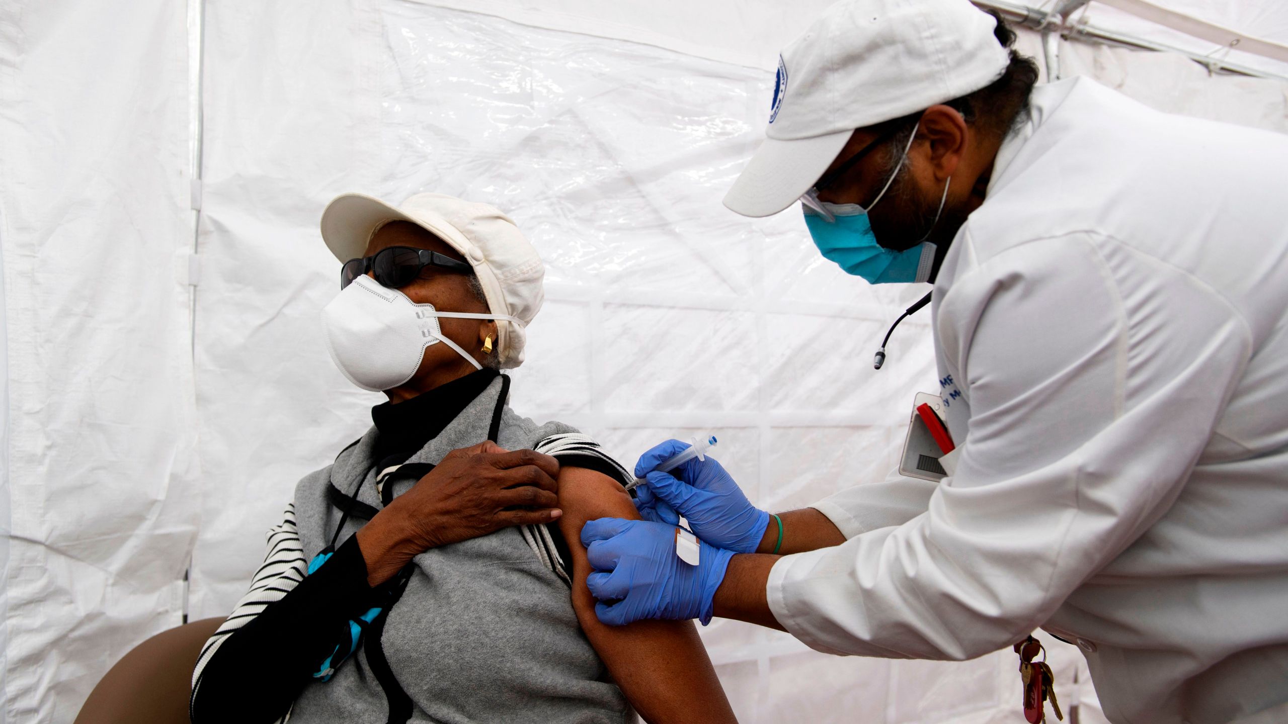 Dr. Jerry P. Abraham administers a Covid-19 vaccination to a senior citizen in a vaccination tent at the Kedren Community Health Center on January 25, 2021 in Los Angeles, California.(Patrick T. Fallon/AFP via Getty Images)