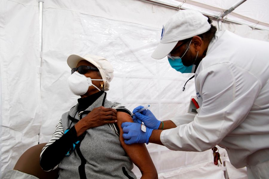 Dr. Jerry P. Abraham administers a Covid-19 vaccination to a senior citizen in a vaccination tent at the Kedren Community Health Center on January 25, 2021 in Los Angeles, California.(Patrick T. Fallon/AFP via Getty Images)