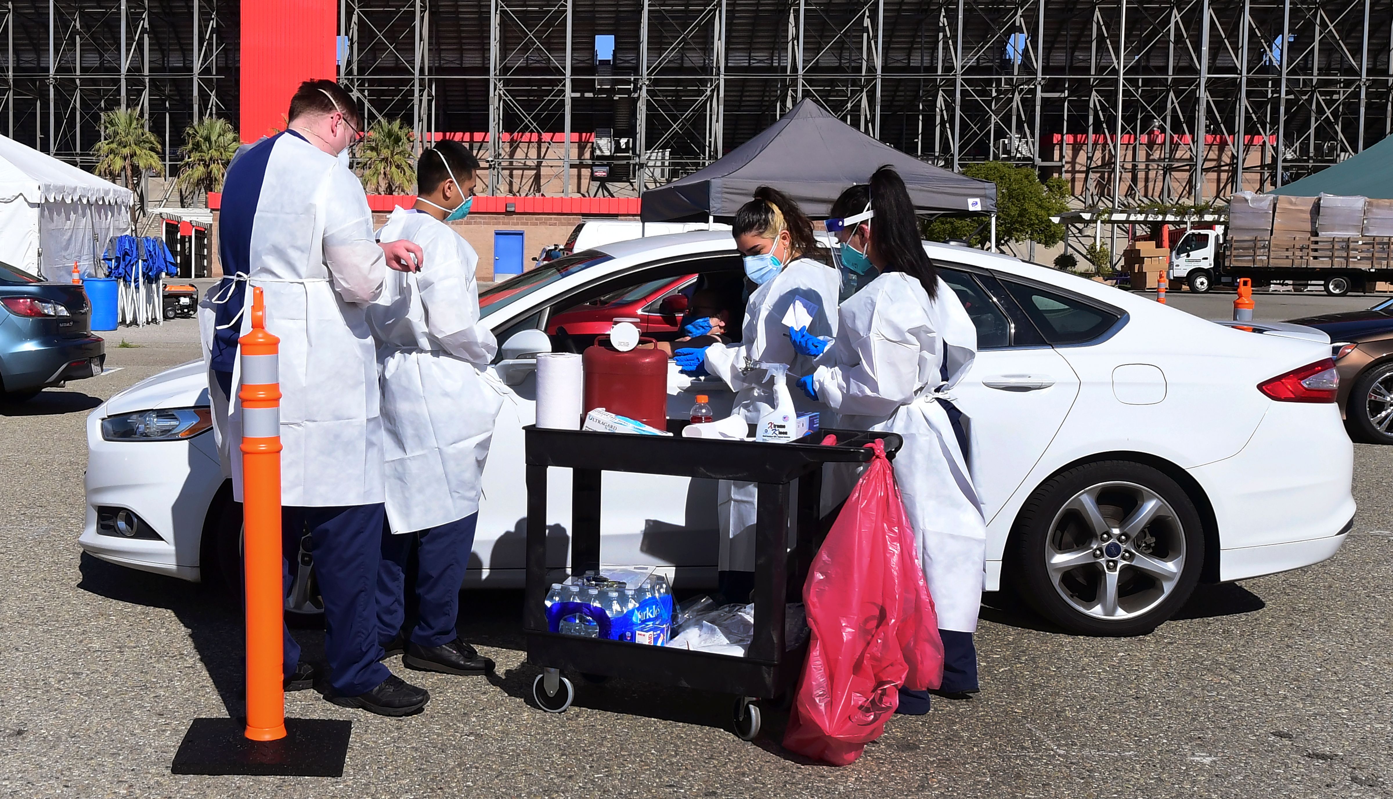 People arrive for their Covid-19 vaccine at the Auto Club Speedway in Fontana, California on February 2, 2021 - The first Covid-19 vaccine 'super site' in San Bernadino County - California's largest county - opened on Tuesday. (Frederic J. Brown/AFP via Getty Images)