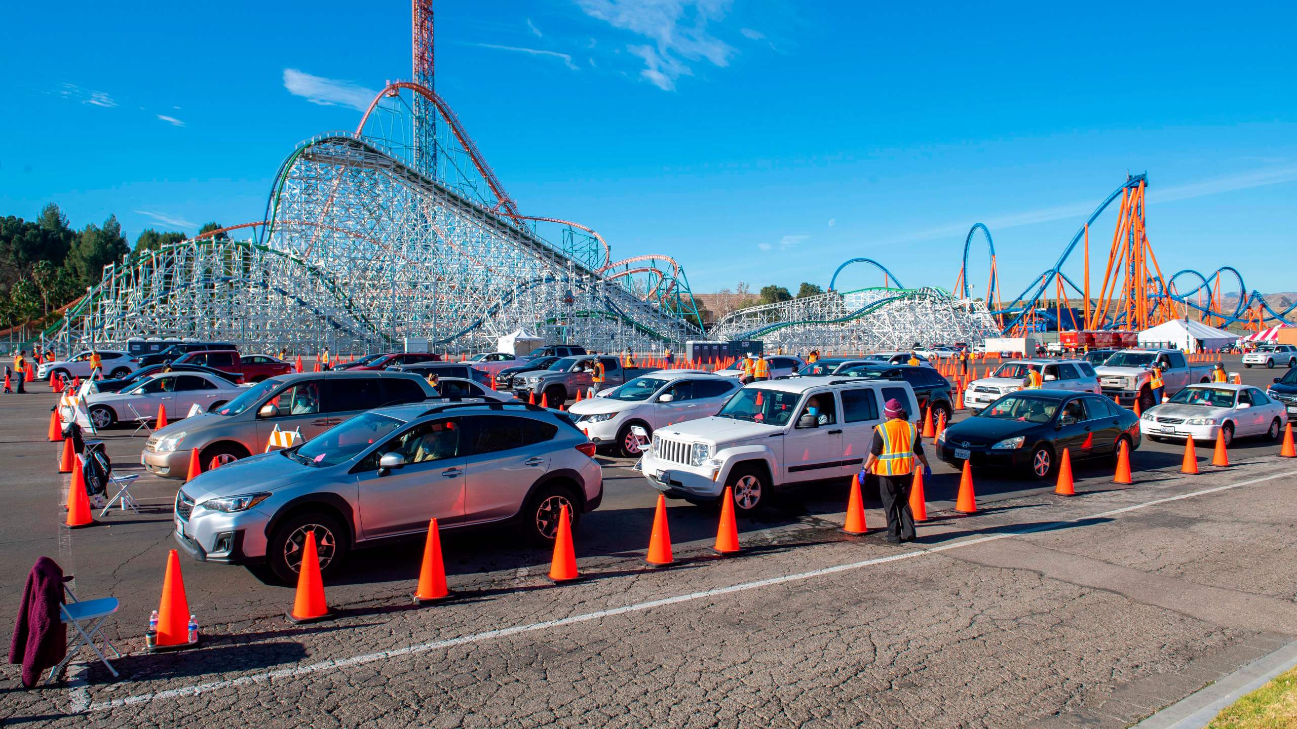 People sit in their cars in an observation area where they are checked for possible side effects after getting their vaccine shot at the large scale COVID-19 vaccination center set up at Six Flags Magic Mountain on Feb. 2, 2021 in Valencia. (VALERIE MACON/AFP via Getty Images)