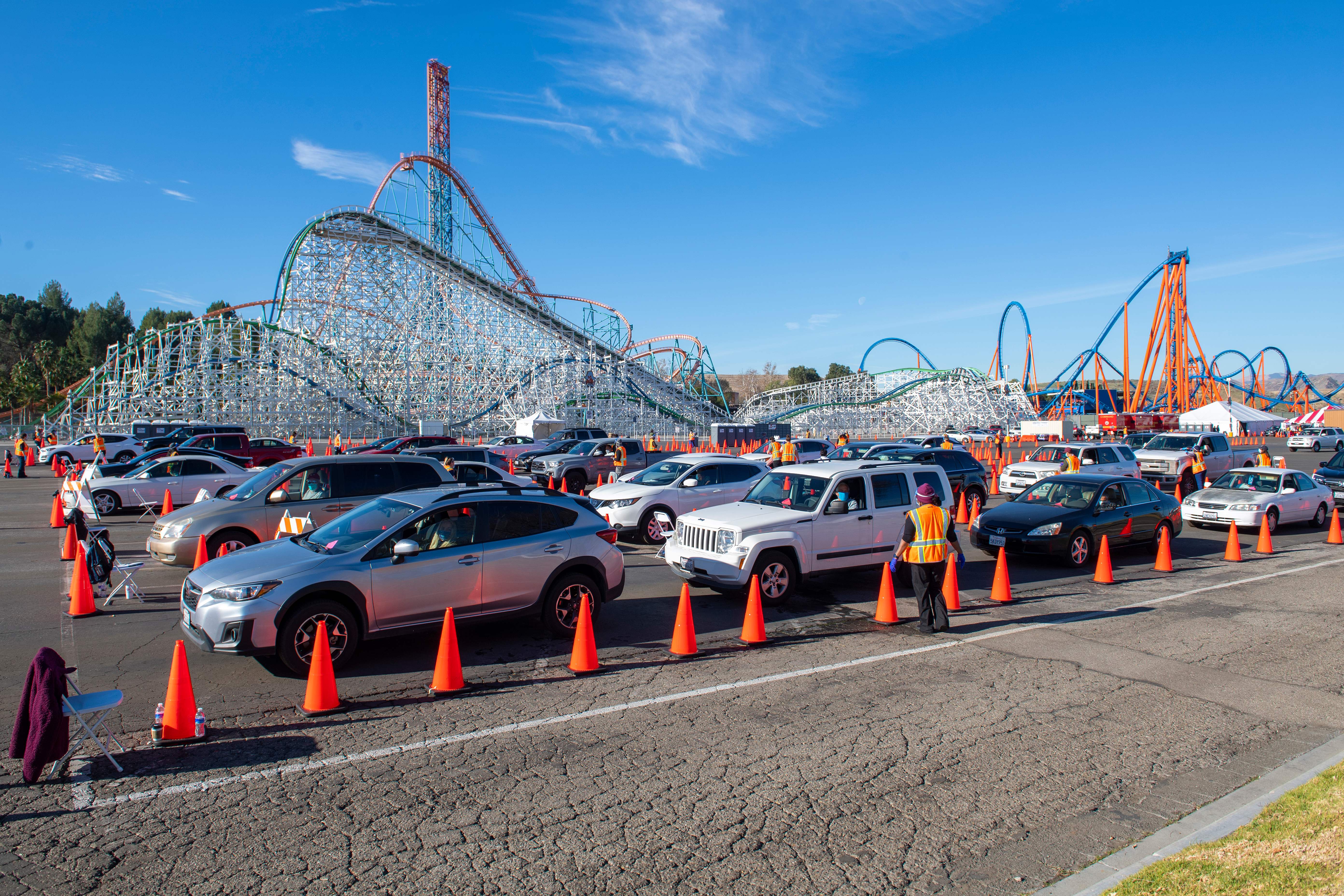 People sit in their cars in an observation area where they are checked for possible side effects after getting their vaccine shot at the large scale COVID-19 vaccination center set up at Six Flags Magic Mountain on Feb. 2, 2021 in Valencia. (VALERIE MACON/AFP via Getty Images)