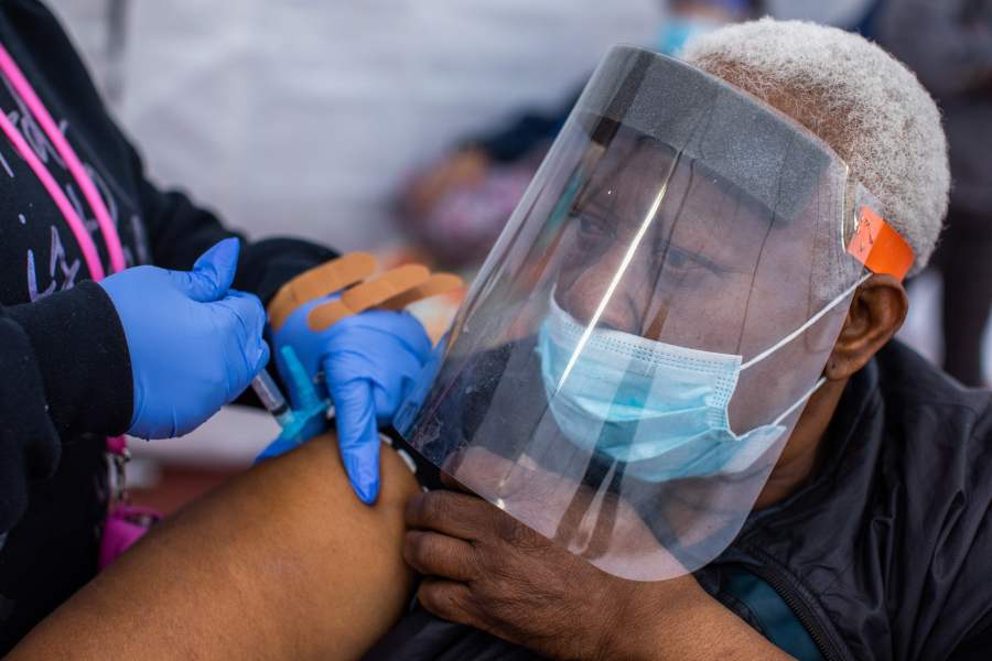 Registered Nurse Ebony Thomas (L) administers a Moderna Covid-19 vaccine to Stella Onwytalu, 89, at Kedren Community Health Center, in South Central Los Angeles, California on February 16, 2021. (Apu Gomes/AFP via Getty Images)